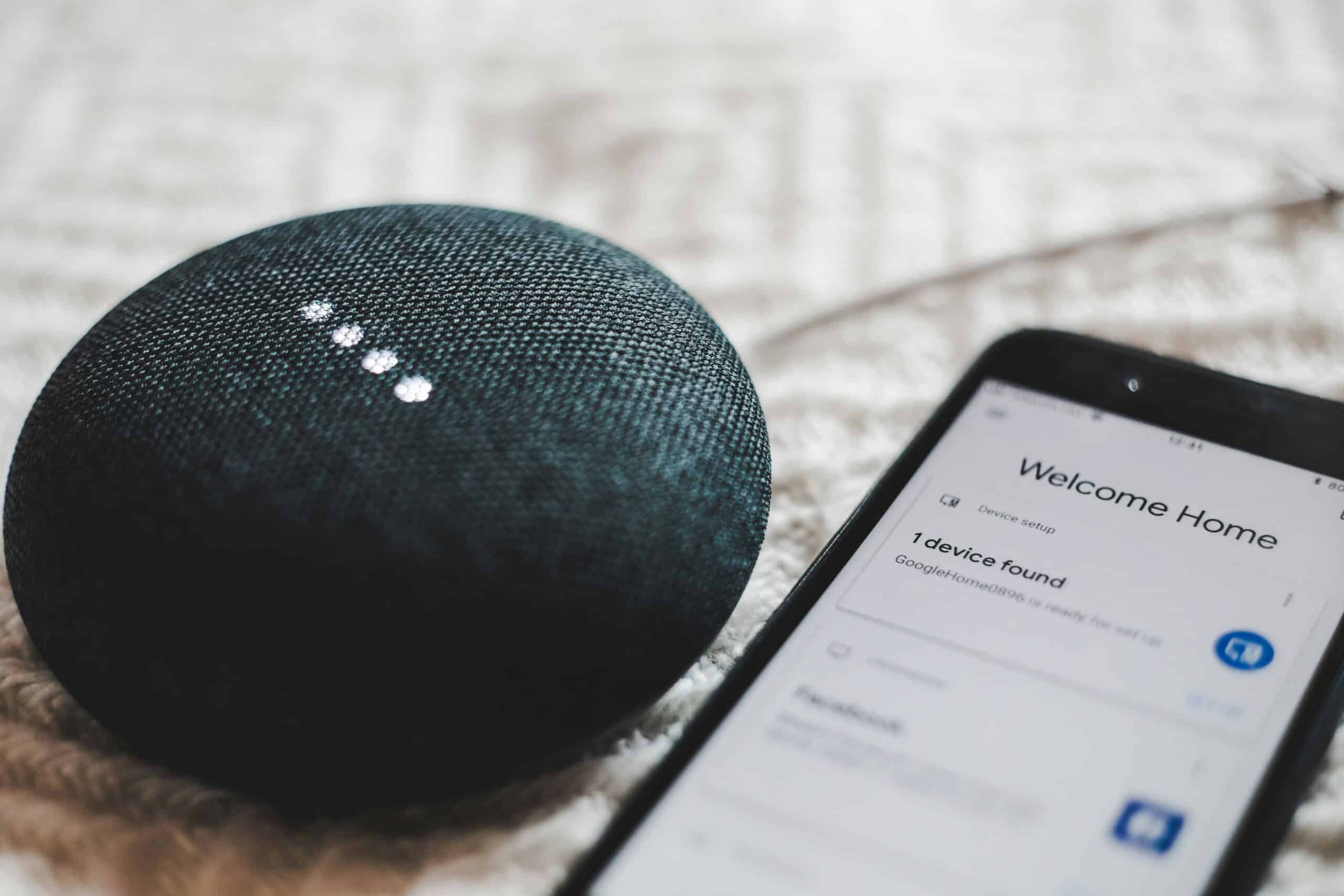 bence-boros-anapPhJFRhM-unsplash-scaled.jpg Turned-on charcoal Google Home Mini and smartphone photo